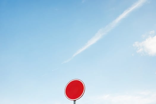 Red circle traffic sign against blue sky photo
