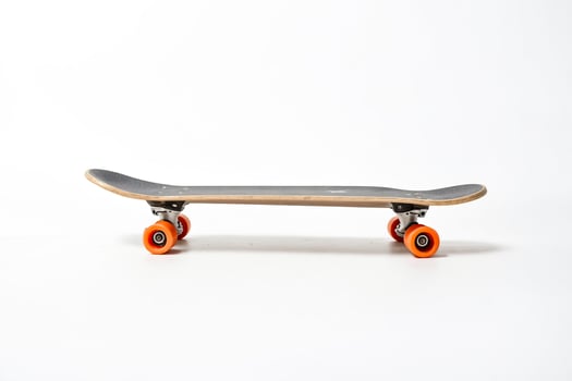 Black skateboard with orange wheels on white background photo