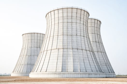 Three Large Cooling Towers in a Desert Landscape photo