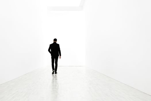 Man walking towards the light in a white room photo