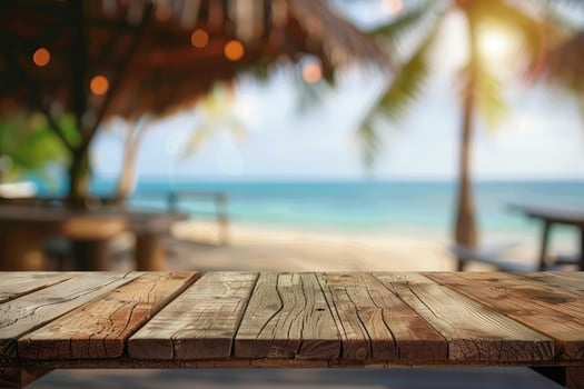 Empty wooden table top with copy space for food drink product advertising with blurred summer resort beach bar restaurant background photo