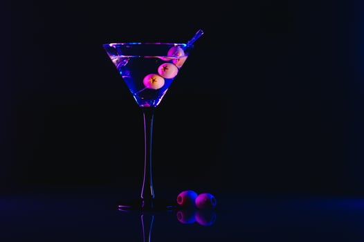 Drink martini. Martini with olives on a black table. Free space for text. photo