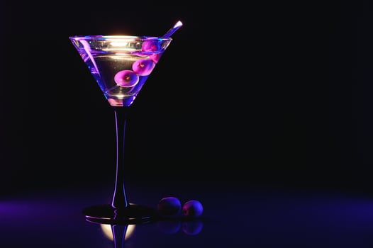 Martini cocktail drink splash with ice cubes in neon iridescent pink and blue colors. Minimal night party life concept. photo