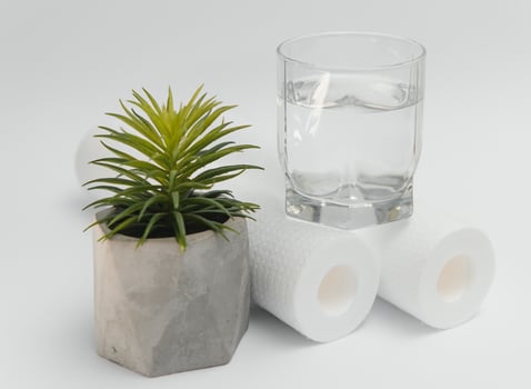 Water filters. Carbon cartridges and a glass on a white background. Household filtration system photo