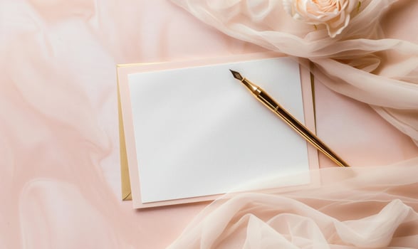 White blank card in a golden frame on a pastel blush pink background photo