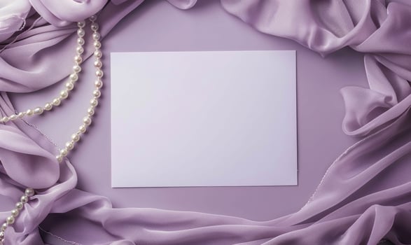 White blank card on a pastel lavender background, with a silk scarf and a pearl necklace photo