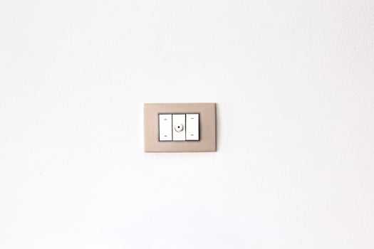 European style wall light switch on a white background. Three sections and dimmer control. Space for copying photo