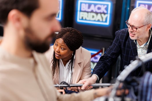 Rude unpleasant shoppers arguing and fighting while hunting for Black Friday deals in clothing store, grabbing discounted fashion items and yelling at each other. People fight over clothes in mall photo