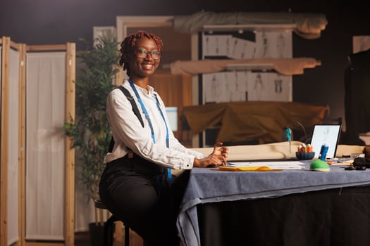 Portrait of happy african american seamstress entrepreneur working in black owned atelier shop business. Professional smiling couturier designing sartorial bespoken outfits for upcoming comission photo