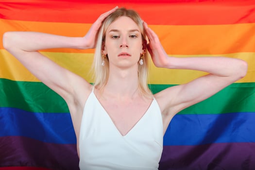 Fashionable young transgender woman on color background photo