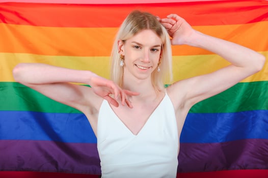 Fashionable young transgender woman on color background photo