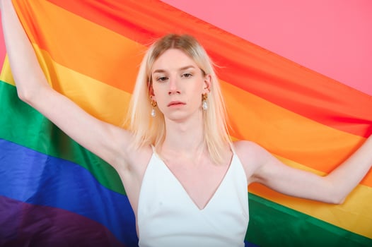 Fashionable young transgender woman on color background photo