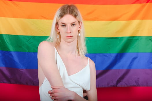 Fashionable young transgender woman on color background photo