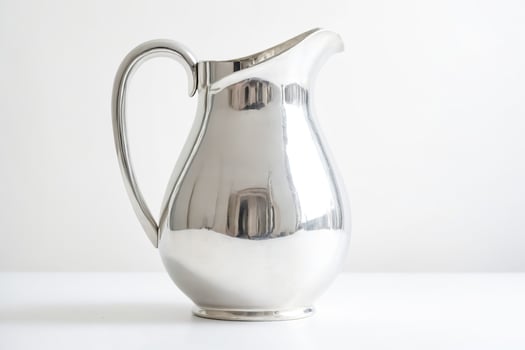 Silver pitcher on white background photo