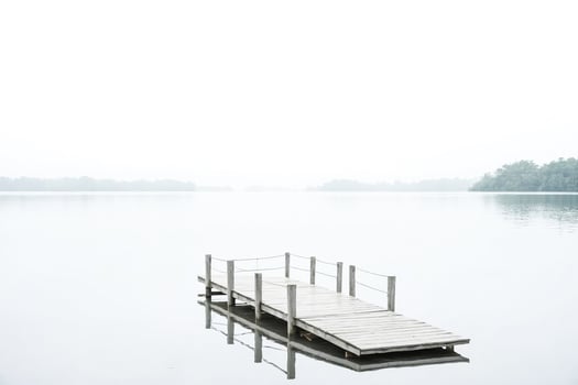 Wooden Dock Extends Into Misty Lake photo