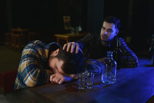 Drunk man sleeps at bar counter, alcohol addiction photo