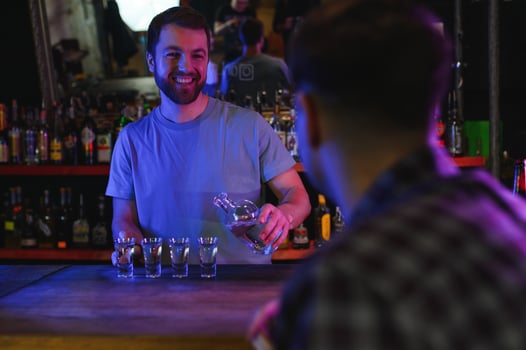 Handsome bar tender standing behind his counter in a pub photo