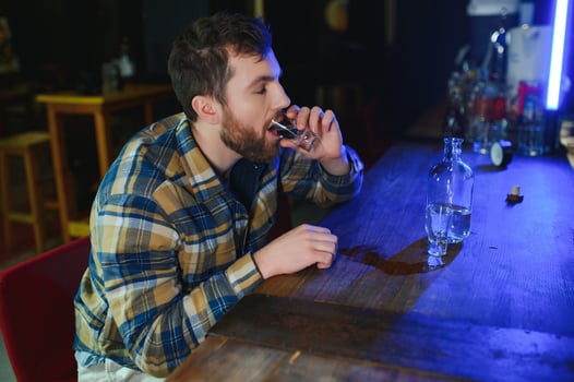 Sad man sitting at bar counter, alcohol addiction photo