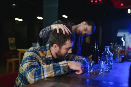 It was a hard day. Depressed young man drinking vodka in bar photo