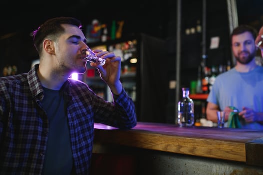 a man drinks vodka at a bar photo
