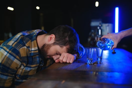 It was a hard day. Depressed young man drinking vodka in bar photo