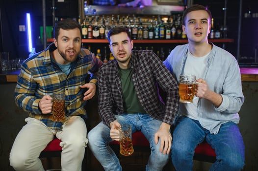Group of excited friends in beer pub watching sports match photo