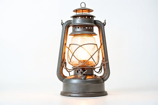Antique Kerosene Lantern with Warm Glow on a White Background photo