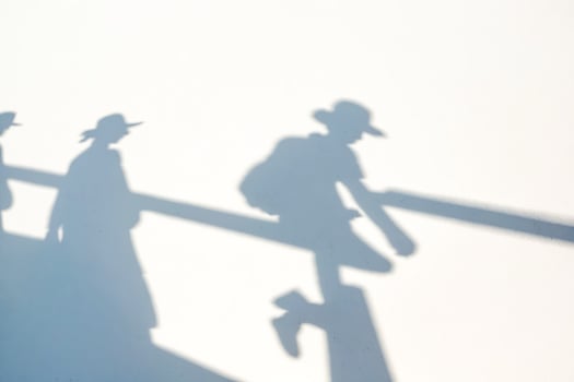 Shadows of People Walking on a White Wall photo