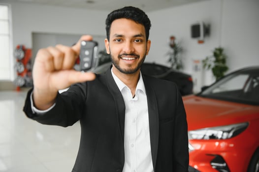 Successful indian businessman in a car dealership - sale of vehicles to customers. photo
