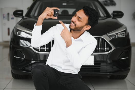 Happy indian man showing the key of his new car photo