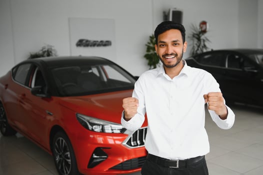 A young Indian man chooses a new car at a car dealership photo