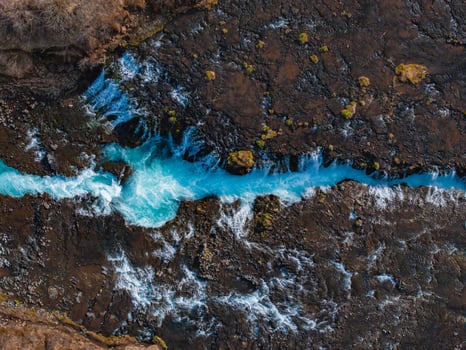 Aerial View of Bright Blue River Flowing Through Rocky Icelandic Landscape photo