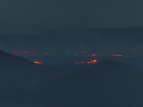 Aerial View of Volcanic Eruption with Red Lava Flows in Iceland photo