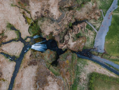 Aerial View of Majestic Icelandic Waterfall Flowing into a Larger River photo