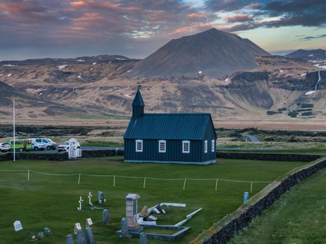 Aerial View of Black Church with Mountain and Pink Sky in Iceland photo