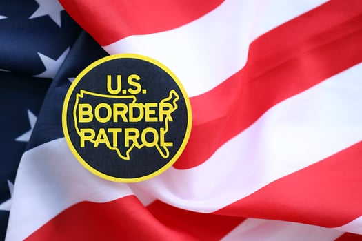 KYIV, UKRAINE - JUNE 26, 2024 U.S. Border Patrol coat of arms sticker on folded US flag photo