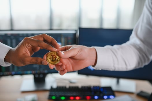 View of hand holding a bitcoin and giving it to other people. Cryptocurrency trading concept photo