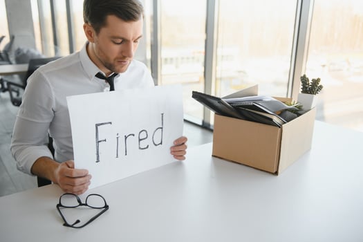 business, firing and job loss concept - fired male office worker with box of his personal stuff. photo