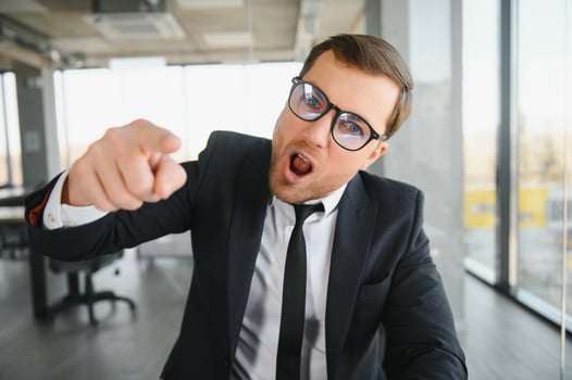 Angry senior businessman sitting at his desk and screaming photo