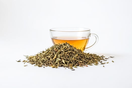A Cup of Tea with Loose Leaf Tea on White Background photo