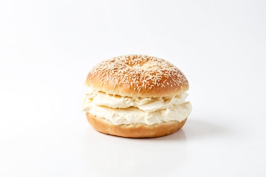 Closeup of a bagel with cream cheese on white background photo