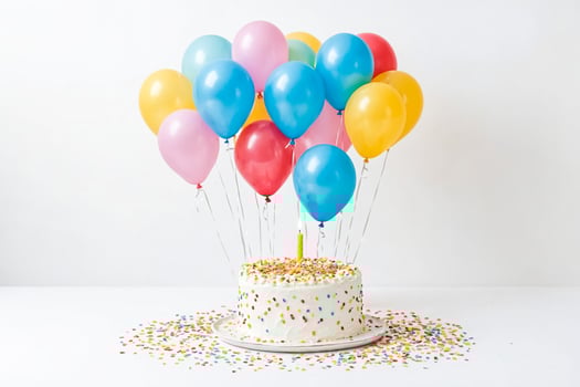 Birthday cake with balloons and confetti photo