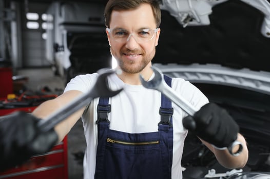 Portrait of a smiling fixing a car engine in his garage photo