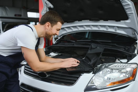 Auto service, repair, maintenance concept. mechanic checks the car, making diagnostics with laptop at the service station. Service maintenance of industrial to engine repair. photo