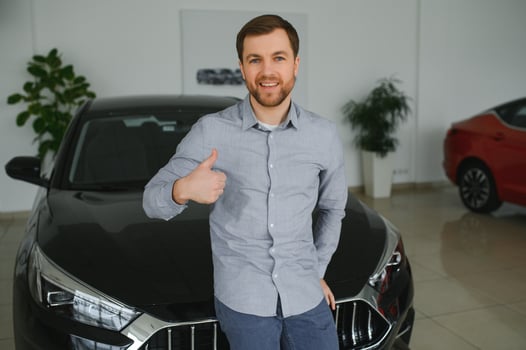 Young man is choosing a new vehicle in car dealership. photo