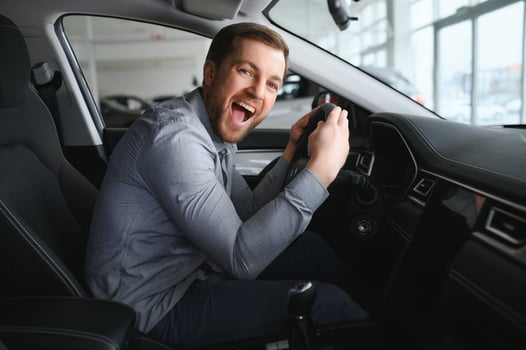 Young man is choosing a new vehicle in car dealership. photo