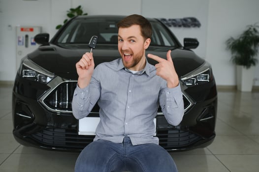 Young man is choosing a new vehicle in car dealership. photo