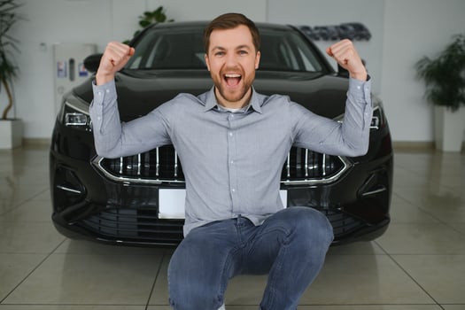 Young man is choosing a new vehicle in car dealership. photo