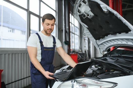 Auto service, repair, maintenance concept. mechanic checks the car, making diagnostics with laptop at the service station. Service maintenance of industrial to engine repair. photo