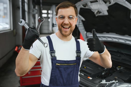 Portrait Shot of a Handsome Mechanic Working on a Vehicle in a Car Service. Modern Clean Workshop. photo